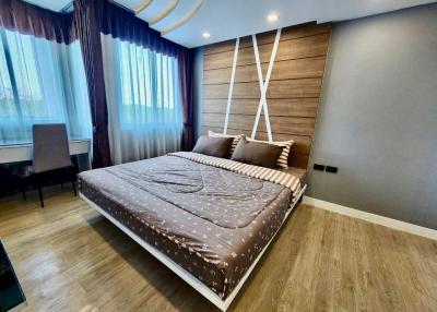 Modern bedroom with large bed and wooden accent wall