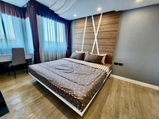 Modern bedroom with large bed and wooden accent wall