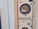 Stacked modern washing machine and dryer in a home laundry closet