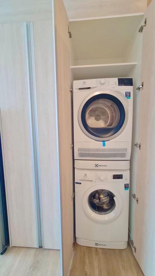 Stacked modern washing machine and dryer in a home laundry closet