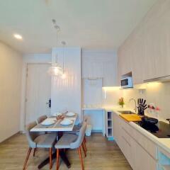 Modern kitchen with dining space featuring elegant light fixture and contemporary design