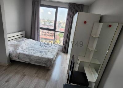 Compact bedroom with a single bed, large window, and wardrobe