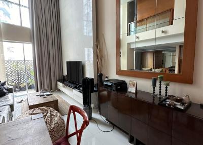 Spacious living room with high ceiling and natural light