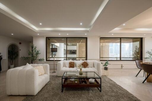 Spacious and well-lit living room with modern furniture and city view