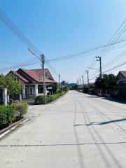 Quiet residential street with houses and clear blue sky