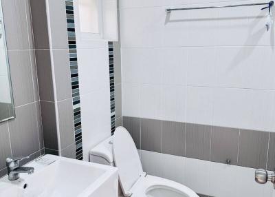 Modern tiled bathroom with white fixtures