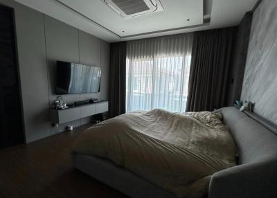 Modern bedroom with large bed and television setup