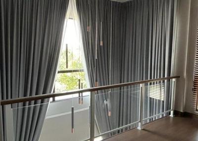 Spacious and well-lit hallway with elegant drapes and wooden flooring