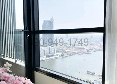 Room with large window overlooking the city skyline and water