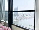 Room with large window overlooking the city skyline and water