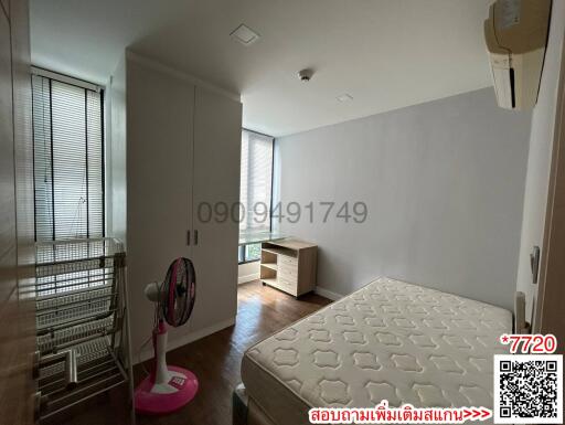 Modern bedroom with a bed, side table, ceiling lights, and air conditioning unit