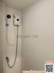 White tiled bathroom showing a wall-mounted electric shower unit