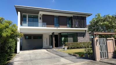 Modern two-story residential home with a driveway and garage under a clear blue sky