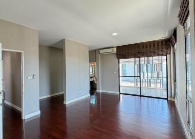 Spacious living room with large windows and hardwood flooring