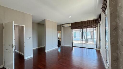 Spacious living room with large windows and hardwood flooring