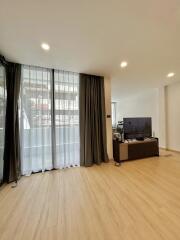 Spacious and well-lit living room with large windows and modern flooring