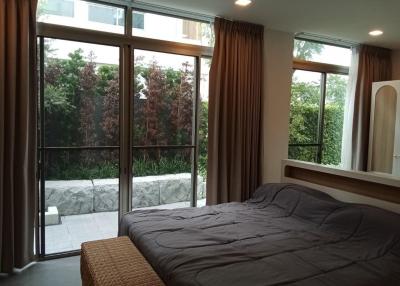 Cozy bedroom with large windows and garden view