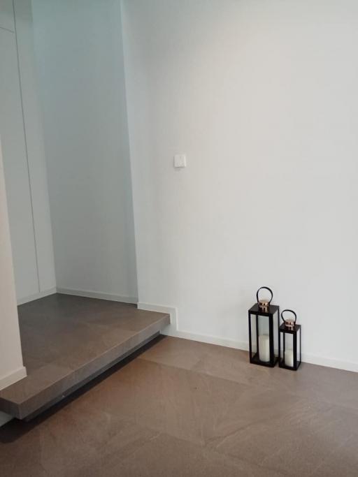 Sparse corner of a room with wooden floor and minimalistic decor