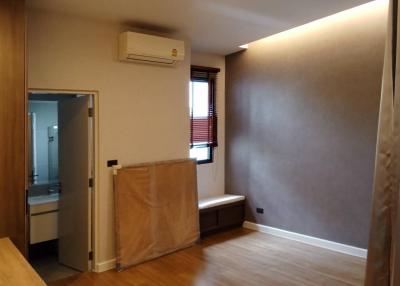 Spacious bedroom with wooden flooring and air conditioning unit