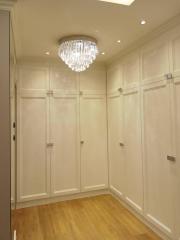 Elegant hallway with chandelier and built-in wardrobes