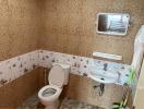 Compact bathroom with patterned tiles, toilet, and sink