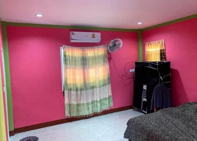 Bright pink bedroom with air conditioning and vibrant curtains