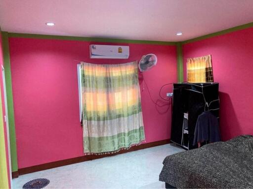 Bright pink bedroom with air conditioning and vibrant curtains