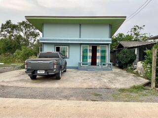 Light blue single-story house with a car parked in front