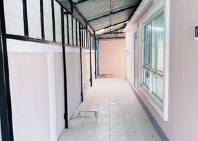 Covered residential corridor with tiled flooring and windows