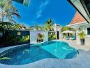 Private swimming pool with tropical plants and a sunny blue sky