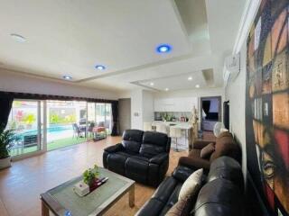 Spacious living room with modern furnishings and access to pool area