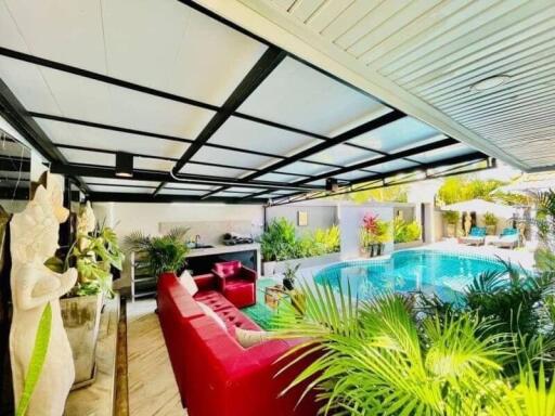 Spacious Covered Patio Area with Comfortable Seating and Pool