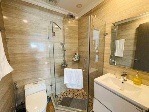 Modern bathroom interior with glass shower and beige tiles