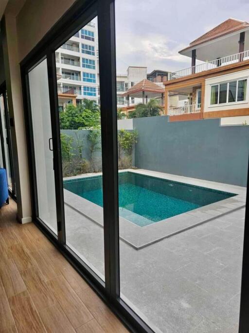 View of a private patio with a swimming pool through sliding glass doors