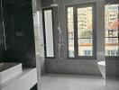 Modern bathroom with marble walls and floors, featuring a standalone bathtub and a separate shower area