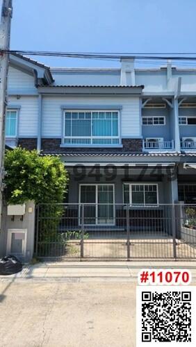 two-story residential townhouse with blue accents and a gated entrance