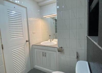 Modern bathroom with white fixtures and marble-like tiles
