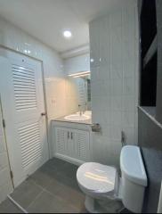 Modern bathroom with white fixtures and marble-like tiles