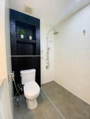 Modern bathroom with white tiles and dark accent wall