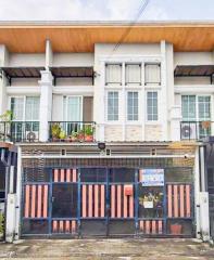 Modern two-story townhouse with gated entrance and balcony