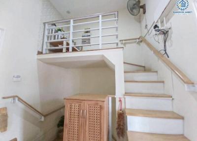 Bright staircase area with under-stairs storage and metal railings