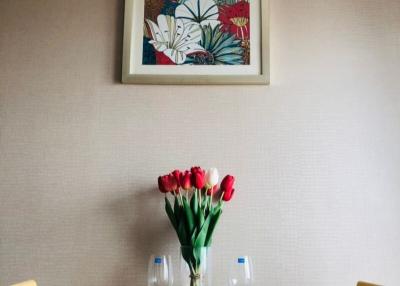 Elegantly set table in a dining room with floral wall art and fresh flowers