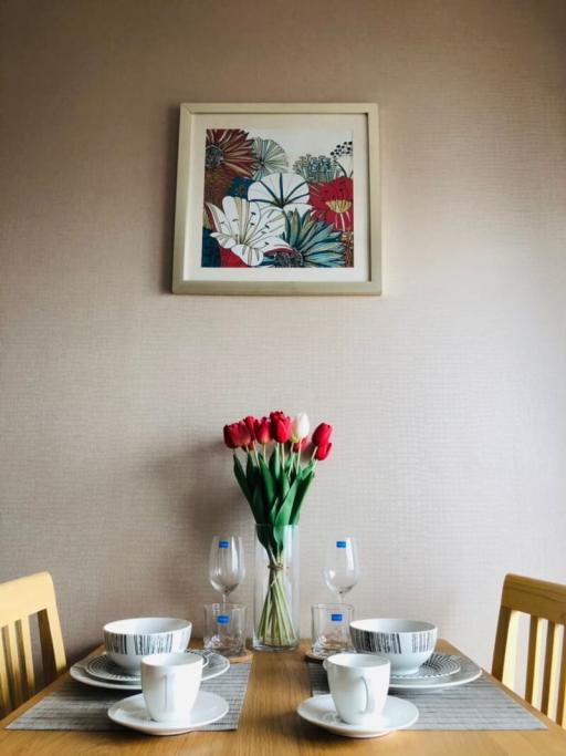 Elegantly set table in a dining room with floral wall art and fresh flowers