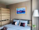 Cozy bedroom with a comfortable bed, wooden wardrobe, and decorative wall art