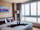 Cozy bedroom with a sea view, large windows, and wall art