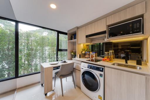 Modern kitchen with combined laundry space, large window, and dining area