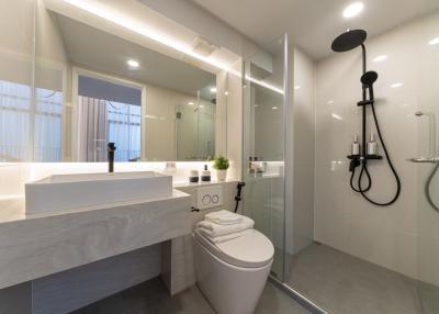 Modern bathroom with well-lit vanity, glass shower, and sleek fixtures
