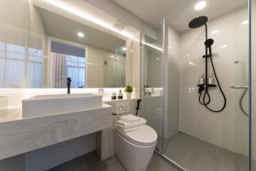 Modern bathroom with well-lit vanity, glass shower, and sleek fixtures