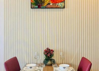 Elegant dining area with a vibrant floral painting and a clean, modern setup