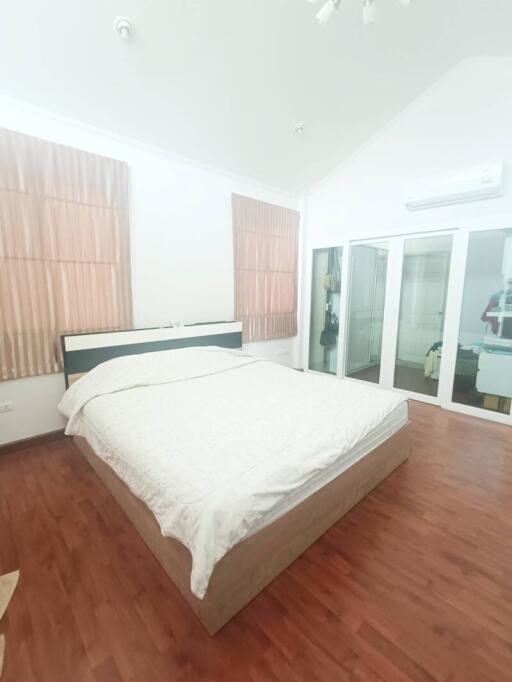 Spacious bedroom with hardwood floors and large bed